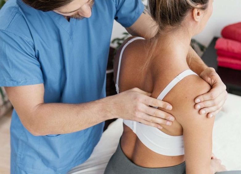 Shoulder Pain: Treatments, Symptoms And Causes 9 High Angle Male Osteopathic Therapist Checking Female Patient S Scapula Scaled E1713757972941
